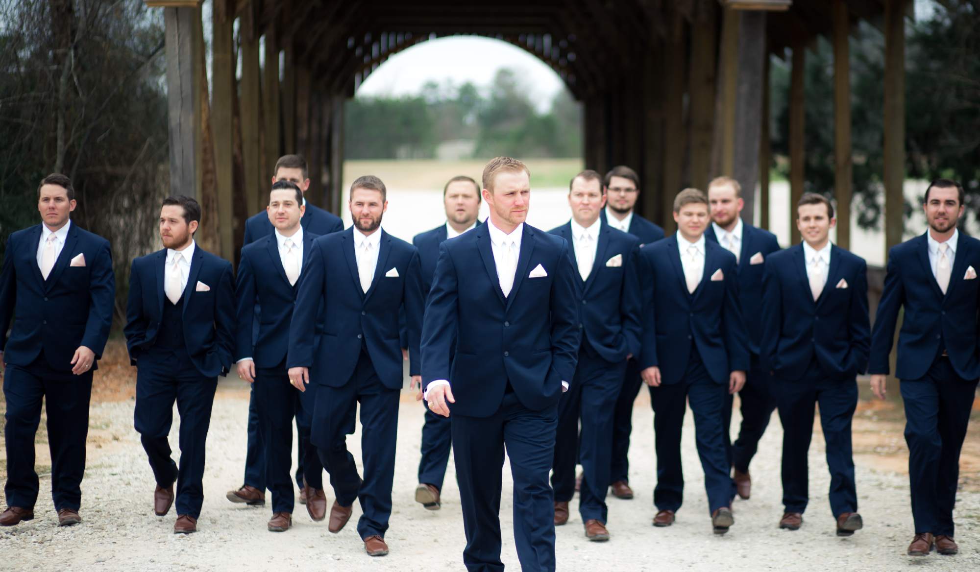 A group of men in suits walking on the street.