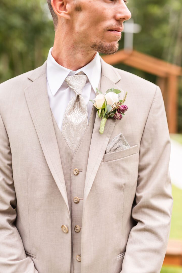 A man in a suit and tie with flowers.