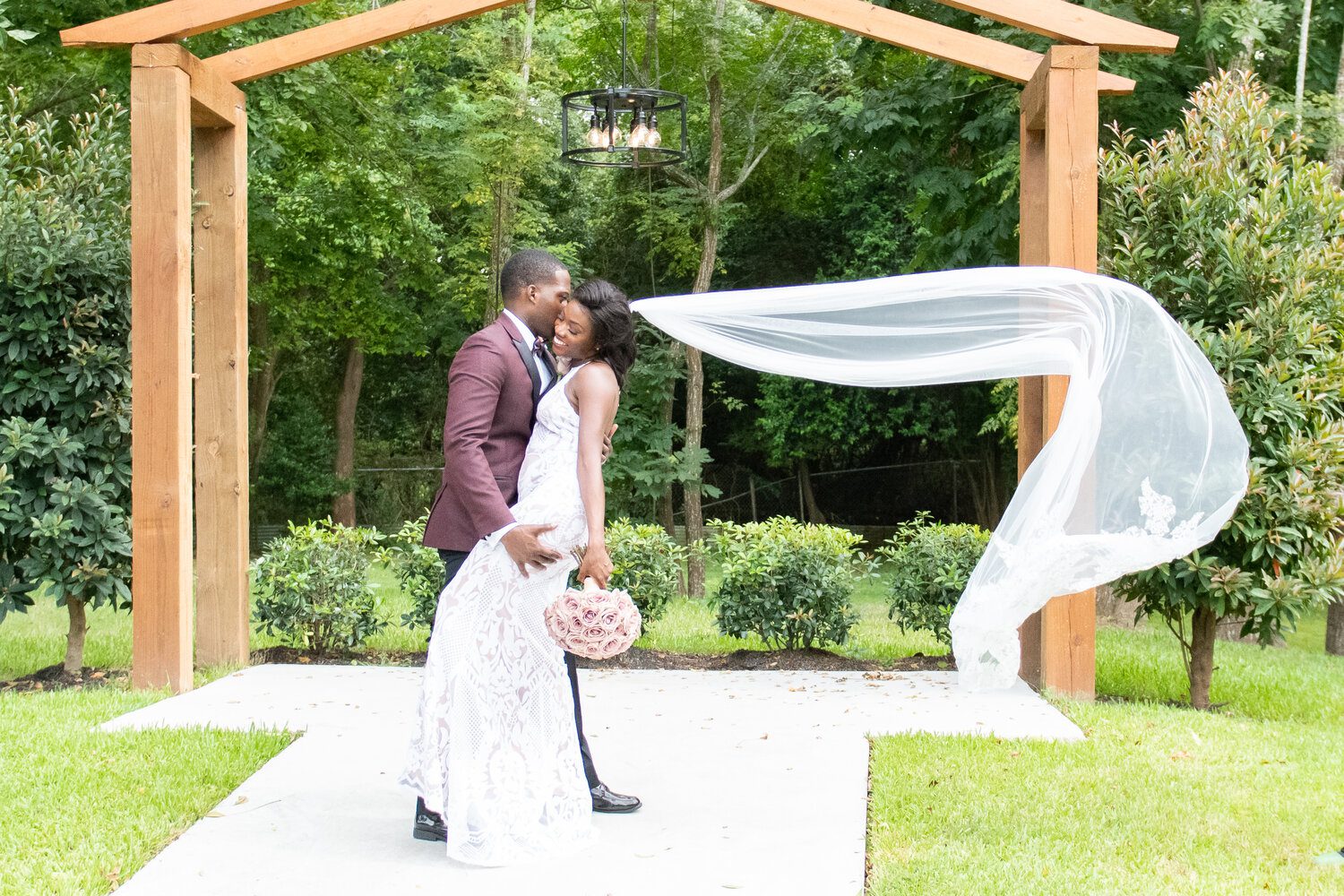 A couple is kissing under an archway.