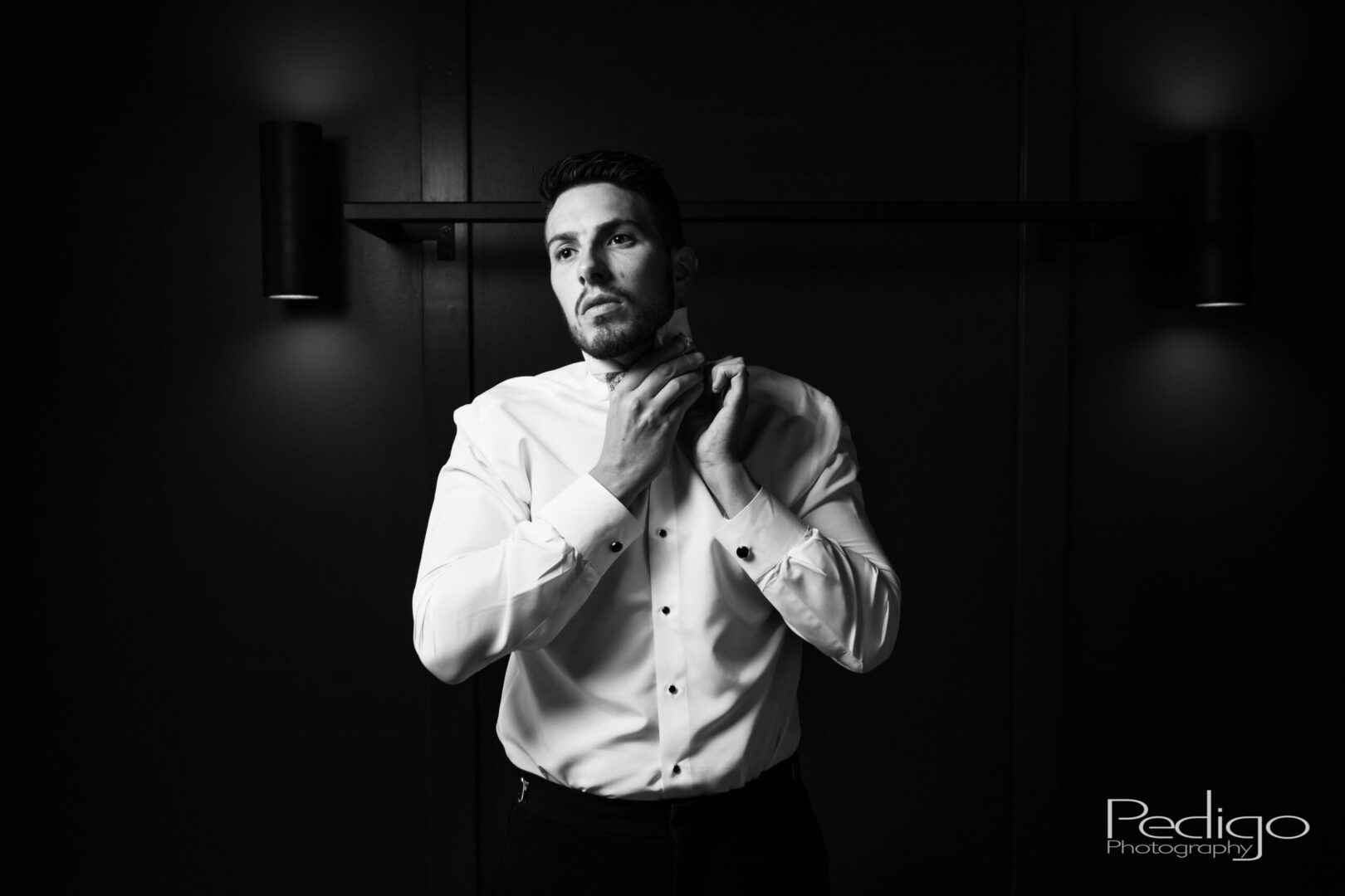 A man in white shirt fixing his tie.