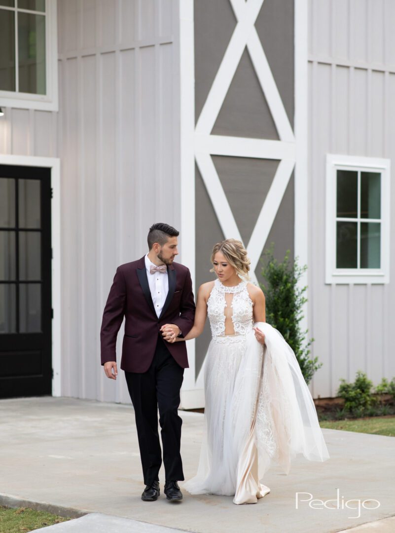 A man and woman walking outside of a barn.