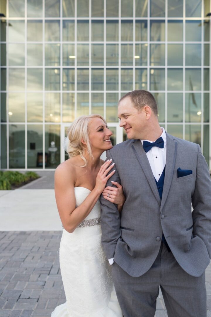 A bride and groom posing for a picture outside of the building.