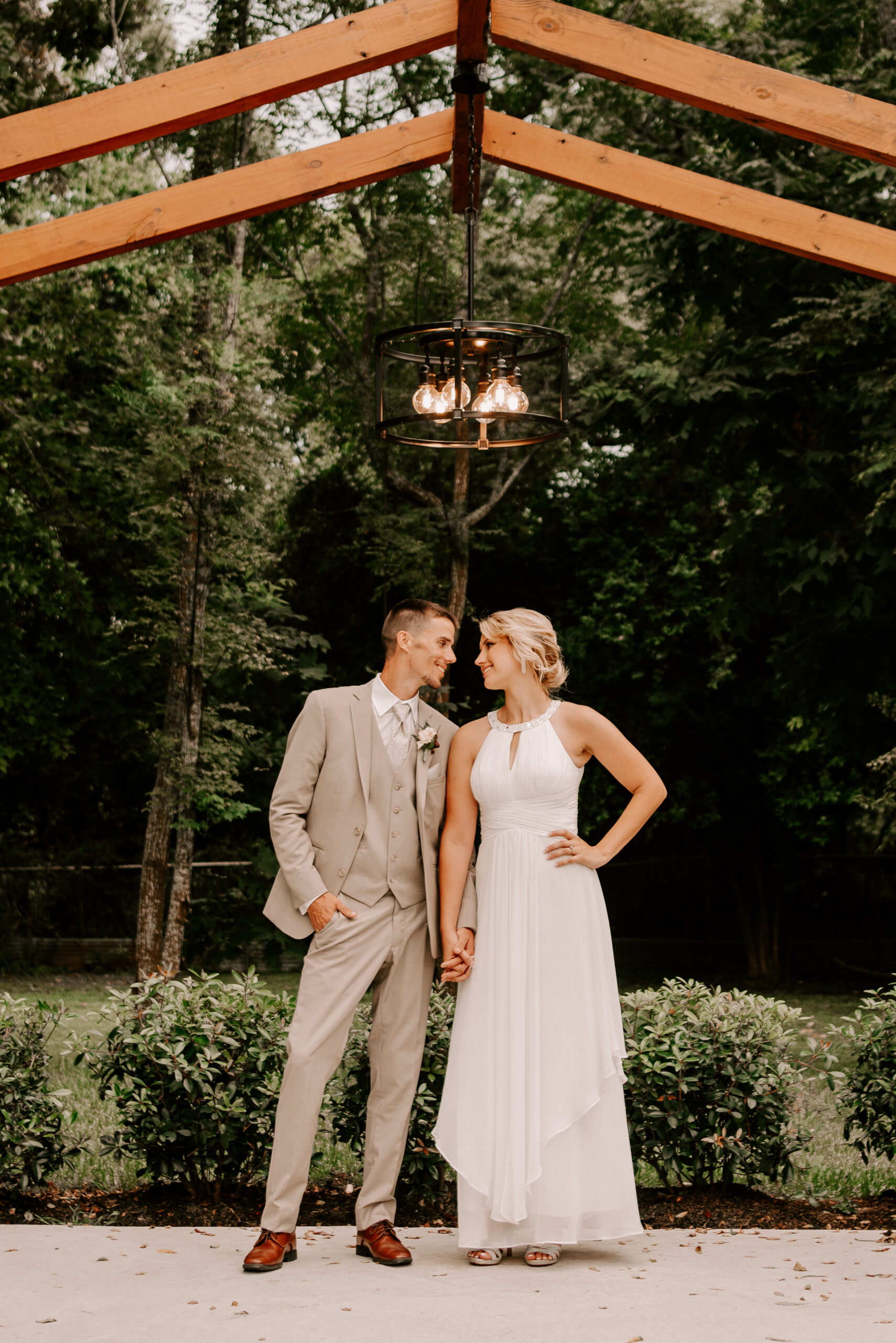 A man and woman standing under an outdoor gazebo.