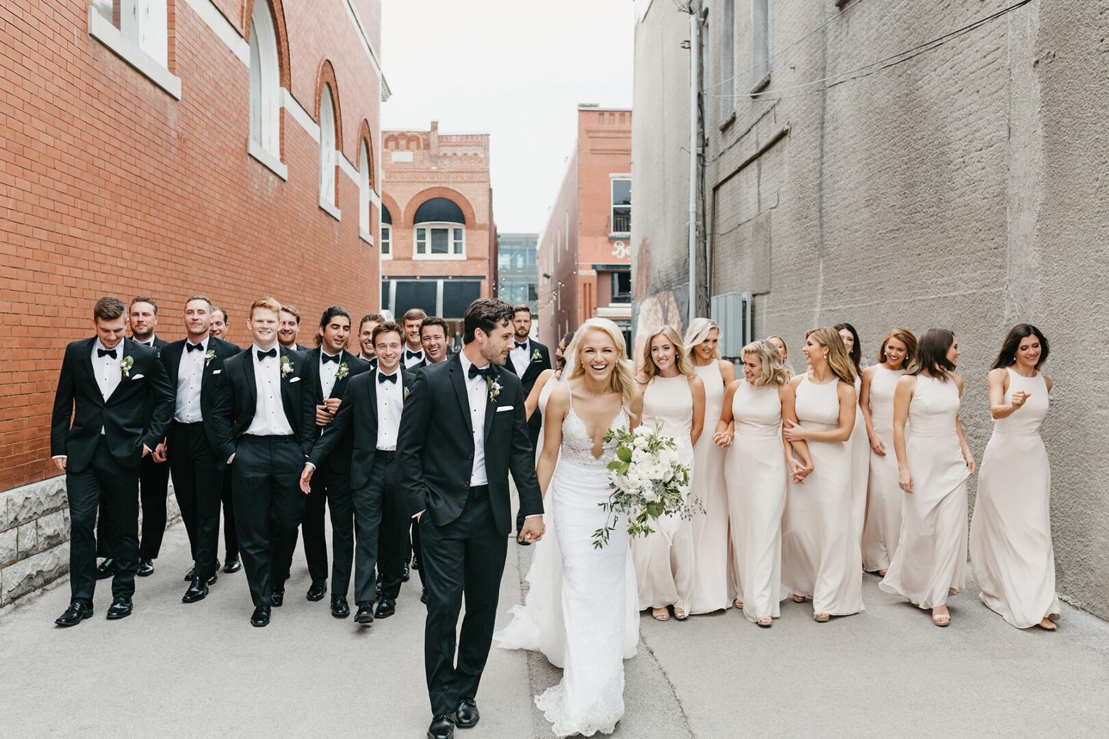 A group of people in tuxedos and white dresses.