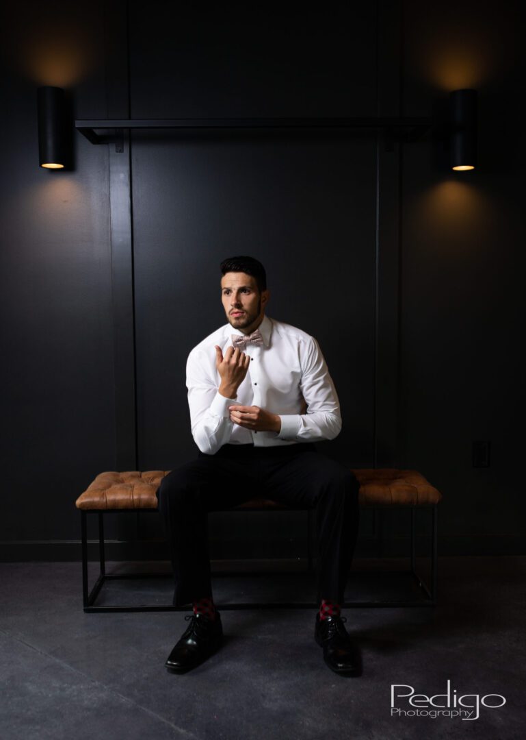 A man sitting on top of a wooden bench.