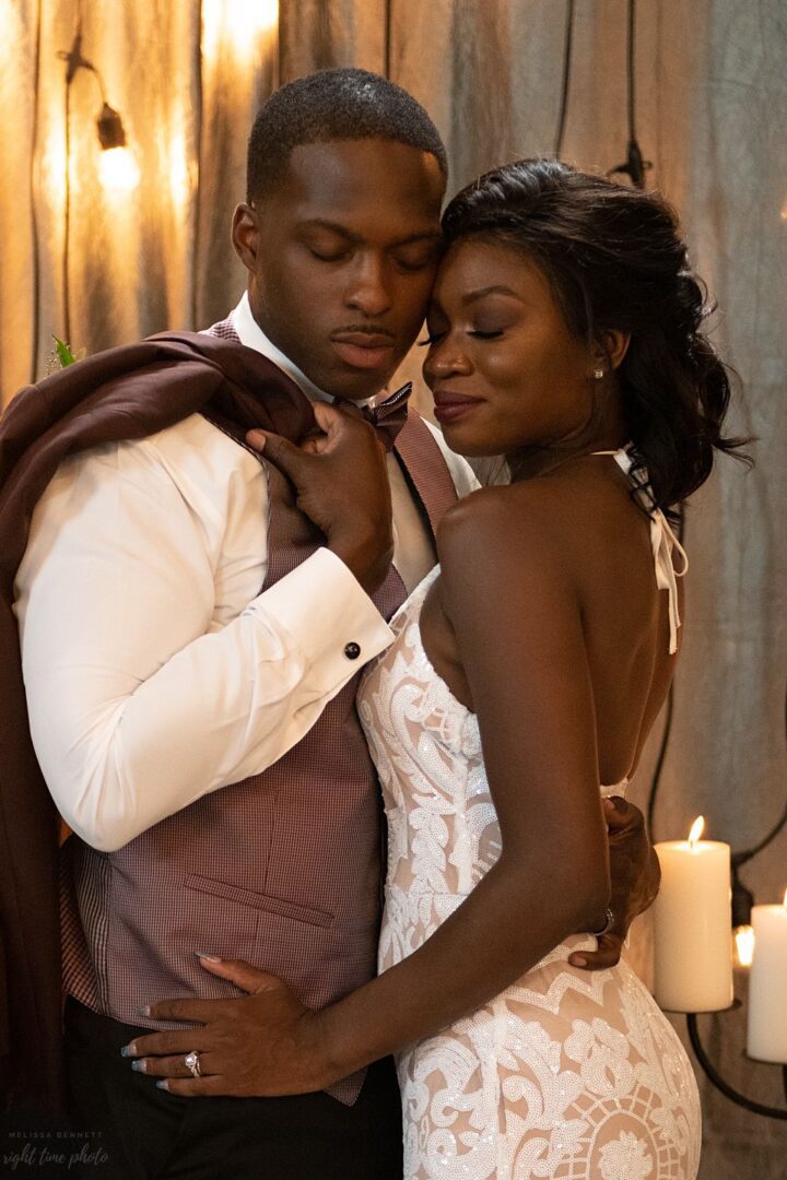 A man and woman embracing in front of candles.