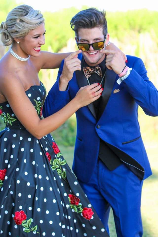 A man and woman in formal wear posing for the camera.