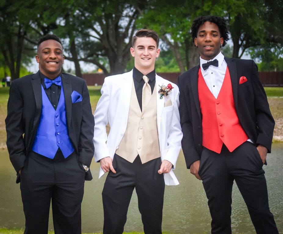 Three young men in suits posing for a picture.