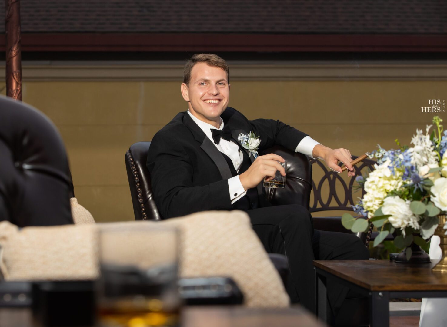 A man in a tuxedo sitting on a chair