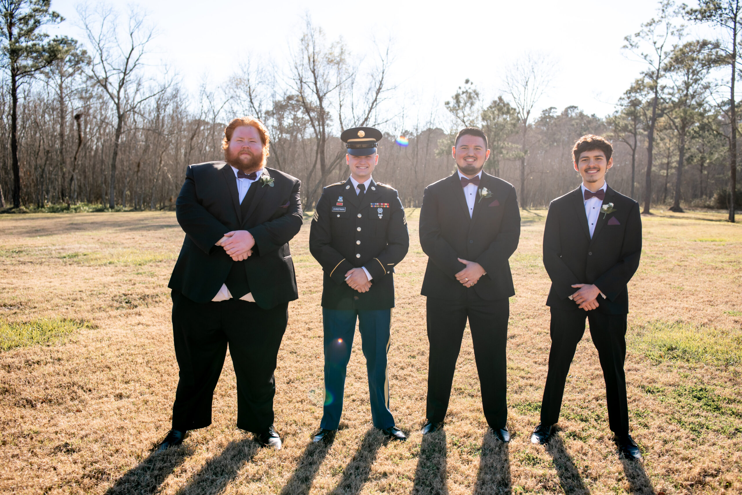 A group of men in suits standing on top of a grass covered field.