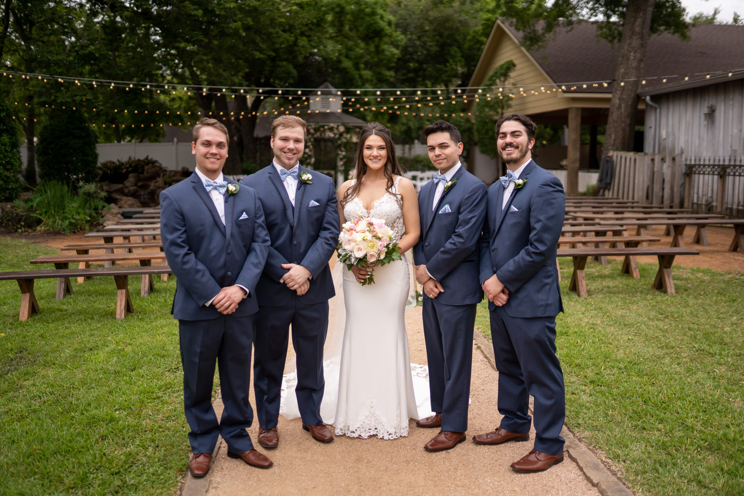 A bride and groom posing with their wedding party.